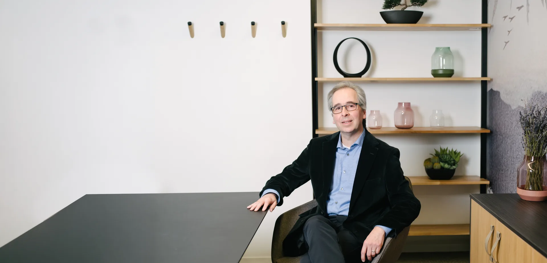 Gary Toste seated at a boardroom table in the Quadshift office